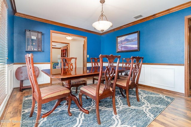 dining area with ornamental molding and wood-type flooring