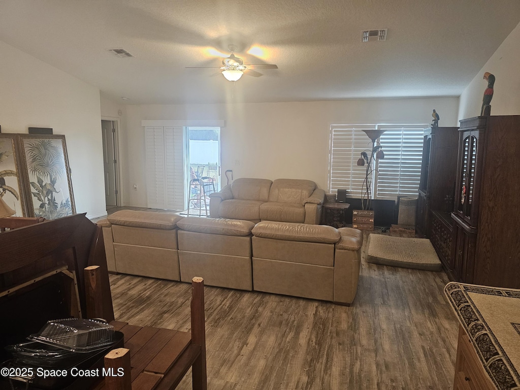 living room featuring ceiling fan and dark hardwood / wood-style flooring