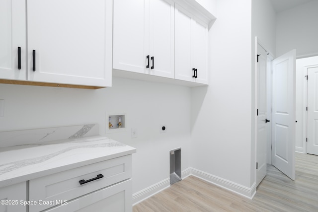 laundry room with hookup for an electric dryer, hookup for a washing machine, cabinets, and light wood-type flooring