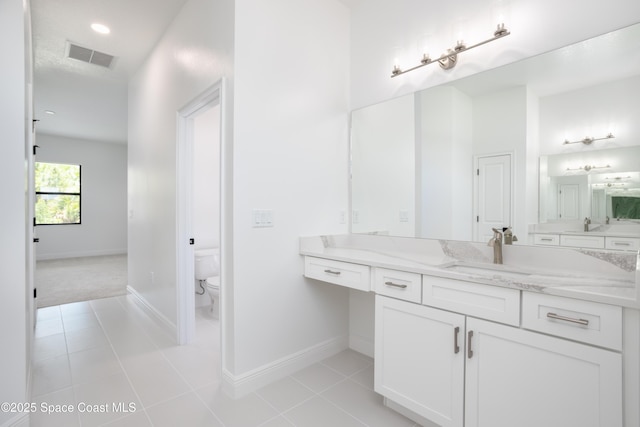 bathroom with vanity, toilet, and tile patterned flooring