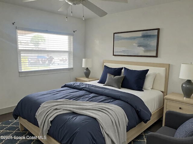 bedroom with ceiling fan and dark hardwood / wood-style flooring