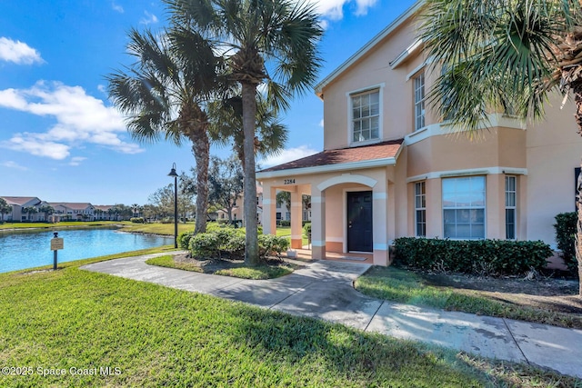 mediterranean / spanish-style house featuring a water view and a front yard