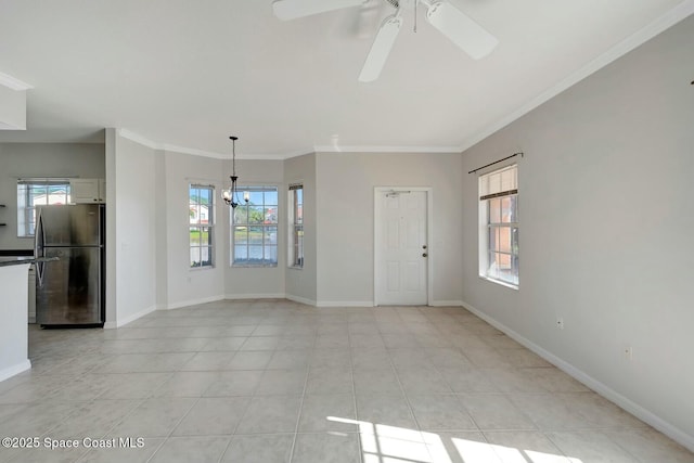 unfurnished living room featuring light tile patterned floors, crown molding, ceiling fan with notable chandelier, and a healthy amount of sunlight