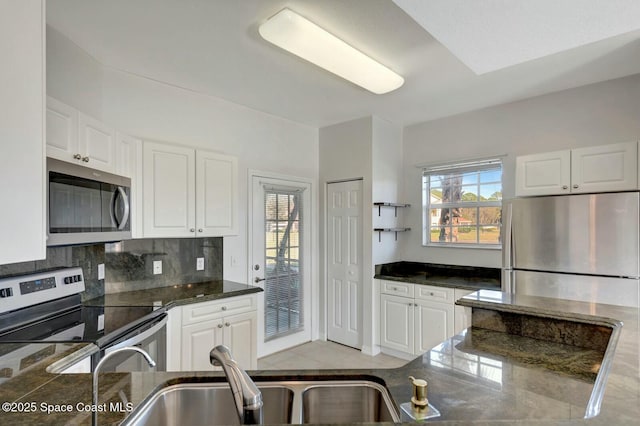 kitchen with stainless steel appliances, tasteful backsplash, a wealth of natural light, and white cabinets