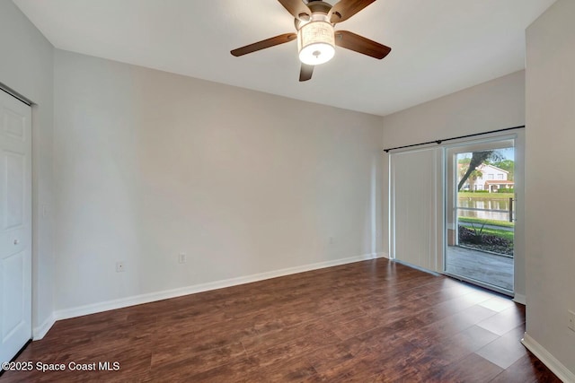 unfurnished room featuring dark wood-type flooring and ceiling fan