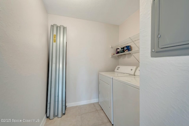 washroom with light tile patterned floors, electric panel, and washing machine and clothes dryer