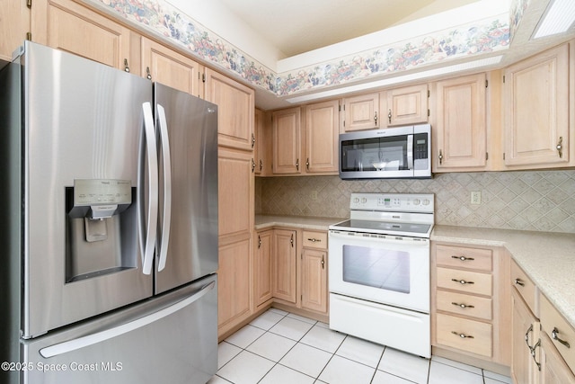 kitchen featuring light tile patterned flooring, stainless steel appliances, light brown cabinetry, and tasteful backsplash