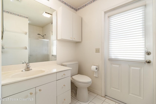 bathroom with vanity, plenty of natural light, a tile shower, and toilet