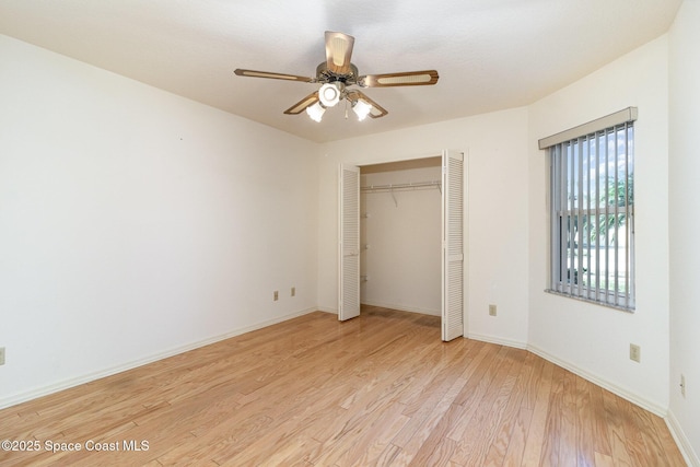 unfurnished bedroom with ceiling fan, light wood-type flooring, and a closet