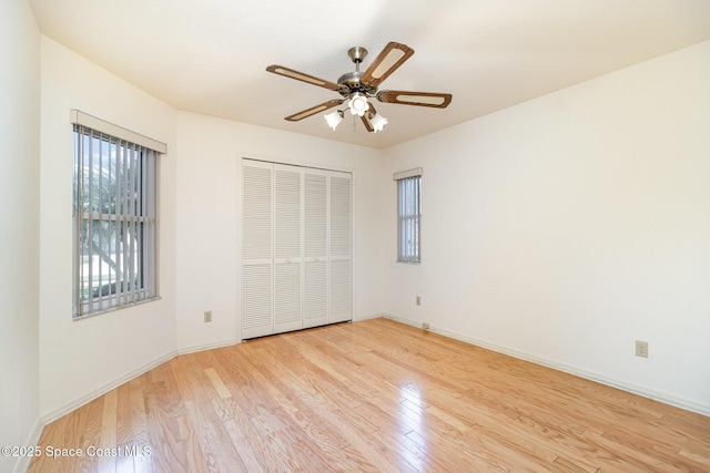 unfurnished bedroom featuring ceiling fan, light hardwood / wood-style floors, and a closet