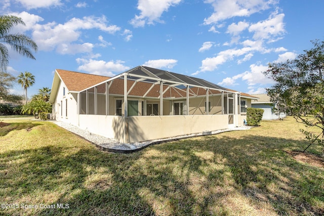 back of property with a lawn and glass enclosure