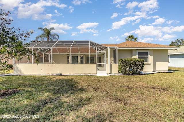 rear view of property with a yard and glass enclosure