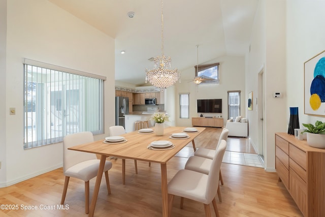 dining area with high vaulted ceiling, light hardwood / wood-style floors, and a healthy amount of sunlight