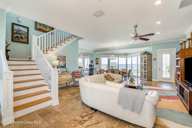 living room with ceiling fan with notable chandelier, ornamental molding, and a textured ceiling