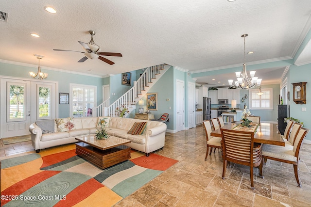 living room with ornamental molding, ceiling fan with notable chandelier, and a textured ceiling