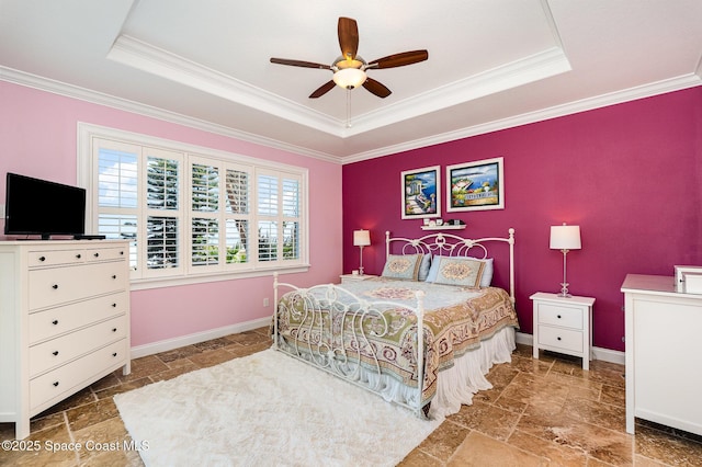 bedroom featuring ceiling fan, ornamental molding, and a tray ceiling