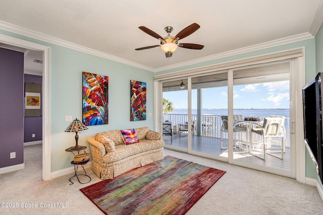 carpeted living room with a water view, ceiling fan, and ornamental molding