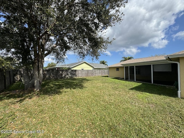 view of yard with a sunroom and a fenced backyard