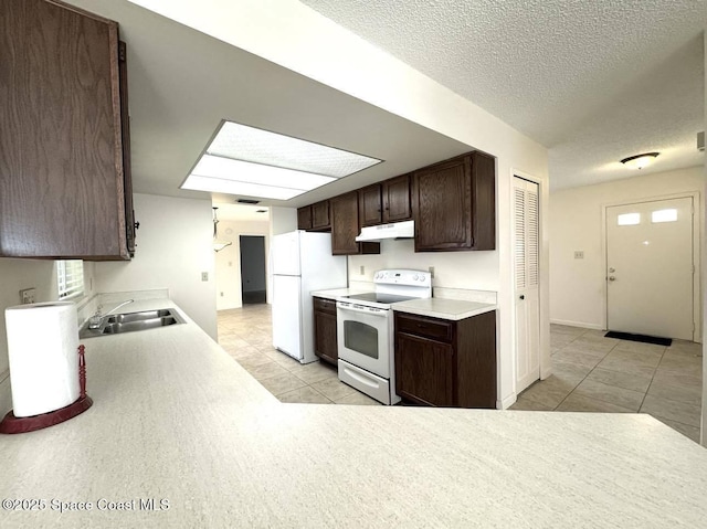 kitchen featuring light countertops, a sink, dark brown cabinets, white appliances, and under cabinet range hood