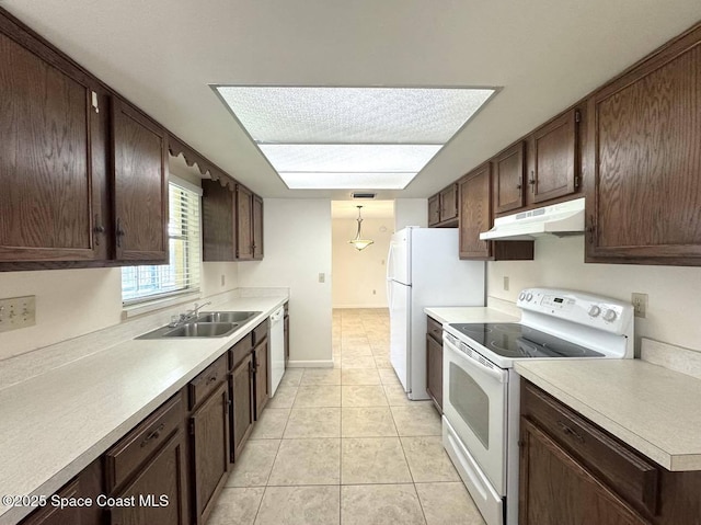 kitchen with light countertops, white appliances, a sink, and under cabinet range hood