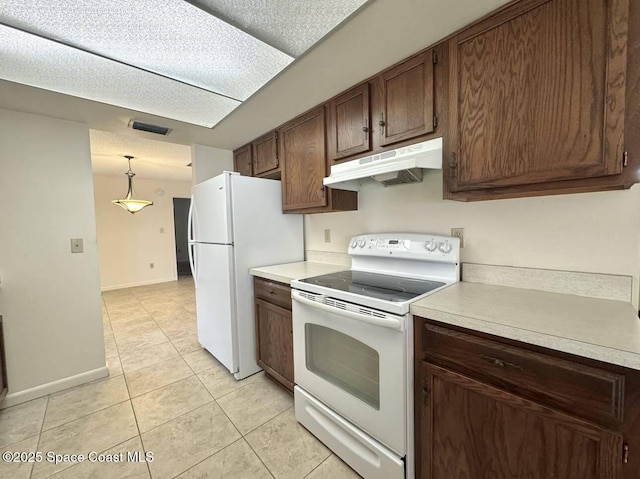 kitchen featuring light tile patterned floors, white appliances, hanging light fixtures, light countertops, and under cabinet range hood