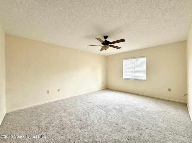 spare room with carpet, ceiling fan, a textured ceiling, and baseboards