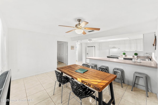 tiled dining space featuring sink and ceiling fan