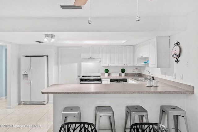 kitchen with white cabinetry, sink, a kitchen breakfast bar, kitchen peninsula, and stainless steel appliances