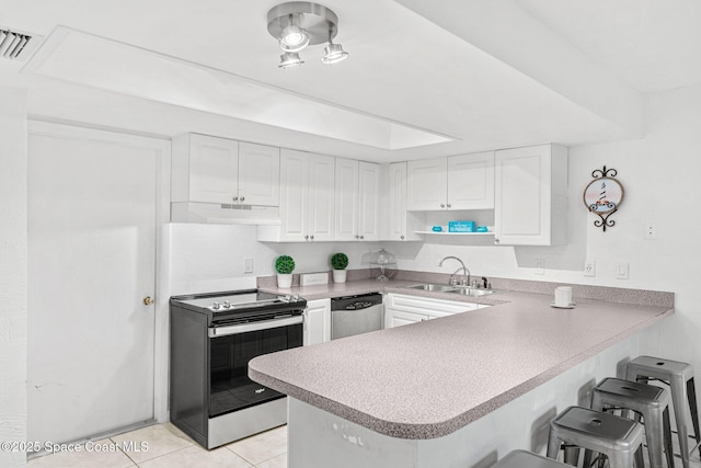 kitchen with appliances with stainless steel finishes, sink, white cabinets, and kitchen peninsula