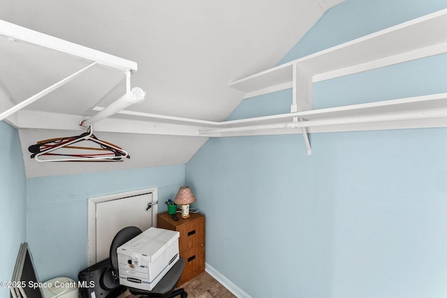 walk in closet with hardwood / wood-style flooring and vaulted ceiling