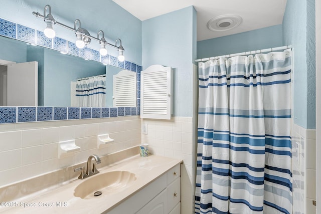 bathroom with tile walls, vanity, radiator, and a shower with shower curtain