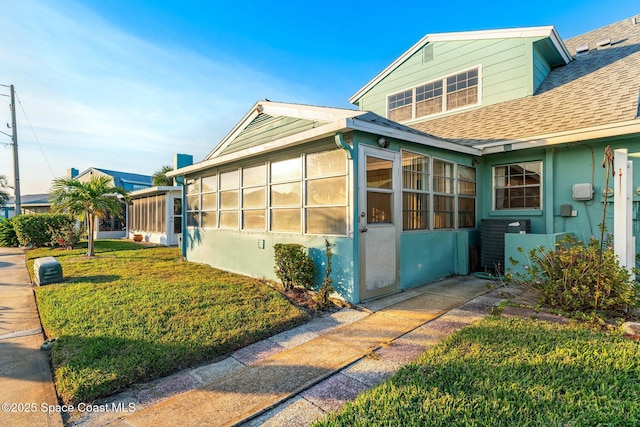 view of property exterior featuring a yard and a sunroom