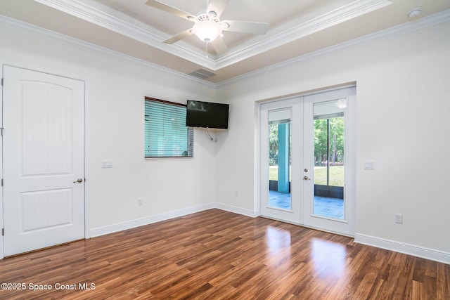 spare room with french doors, wood finished floors, crown molding, and baseboards