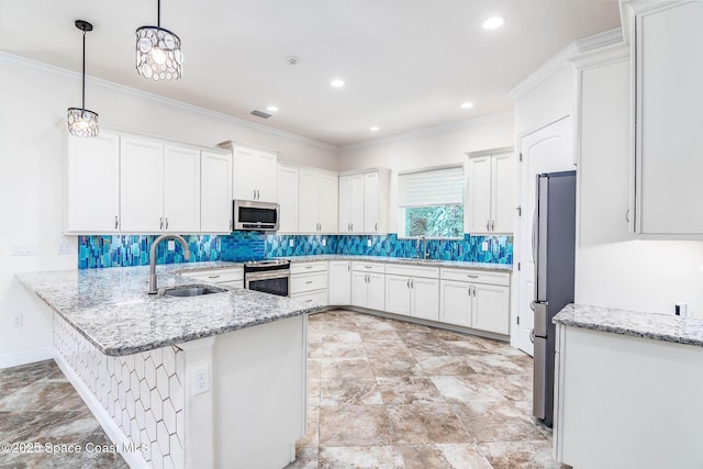 kitchen featuring appliances with stainless steel finishes, a sink, a peninsula, white cabinetry, and ornamental molding