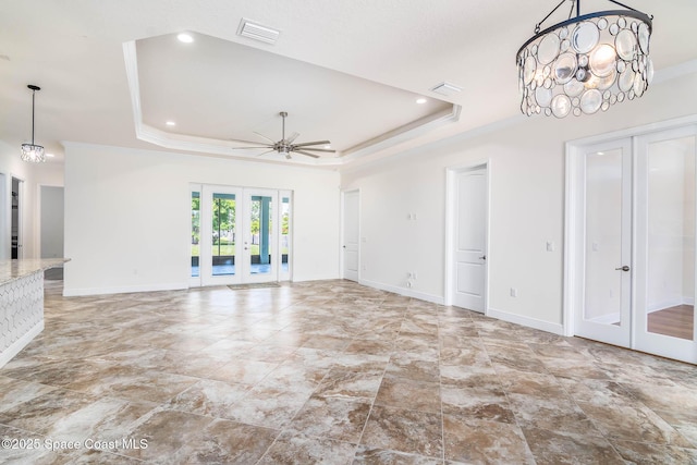 unfurnished living room featuring french doors, a tray ceiling, baseboards, ornamental molding, and recessed lighting