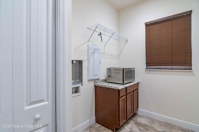 laundry room with baseboards and washer hookup