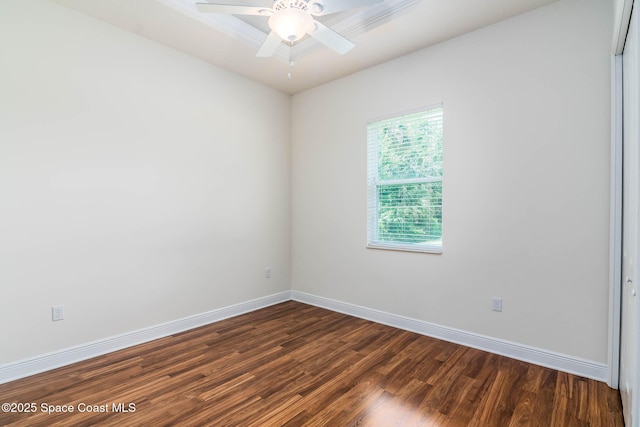spare room with dark wood-style floors, baseboards, and a ceiling fan