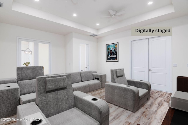 home theater with a tray ceiling, wood finished floors, ceiling fan, and recessed lighting