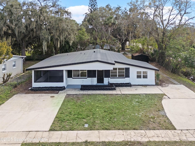 view of front of house with a front lawn and a sunroom