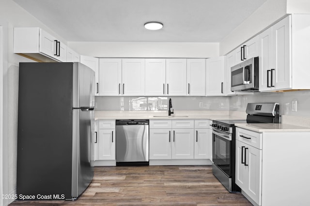 kitchen with white cabinetry, appliances with stainless steel finishes, dark hardwood / wood-style flooring, and sink