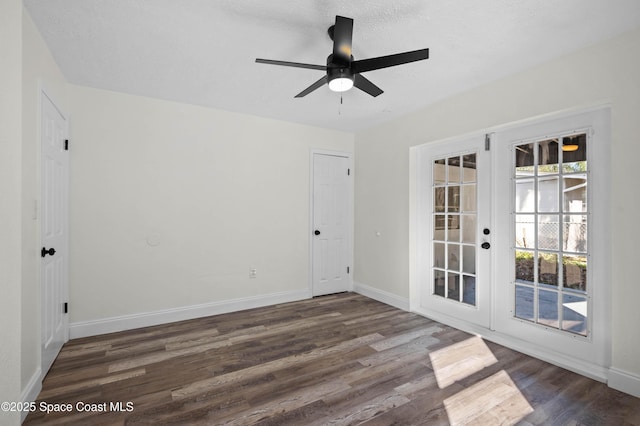 empty room with dark hardwood / wood-style flooring, a textured ceiling, french doors, and ceiling fan