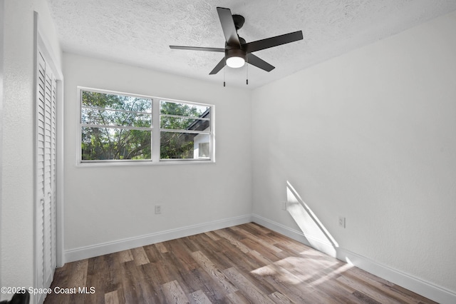 empty room featuring ceiling fan, hardwood / wood-style floors, and a textured ceiling