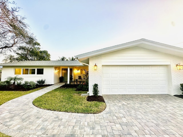 ranch-style home with a garage and a front yard