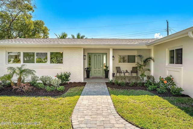 property entrance featuring covered porch and a lawn