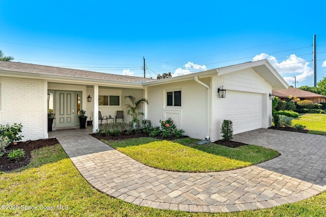 ranch-style house featuring a garage, a porch, and a front lawn