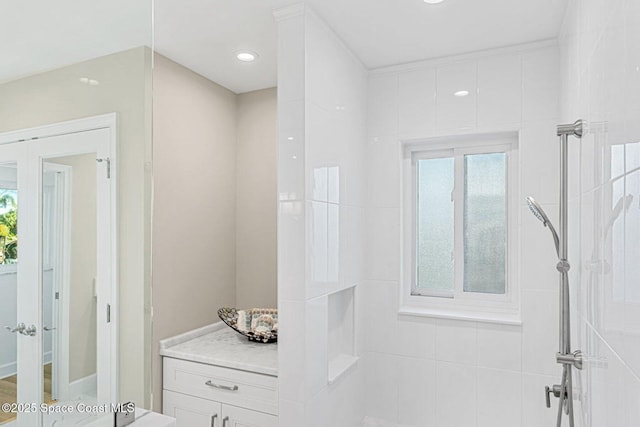 bathroom with tiled shower and a healthy amount of sunlight