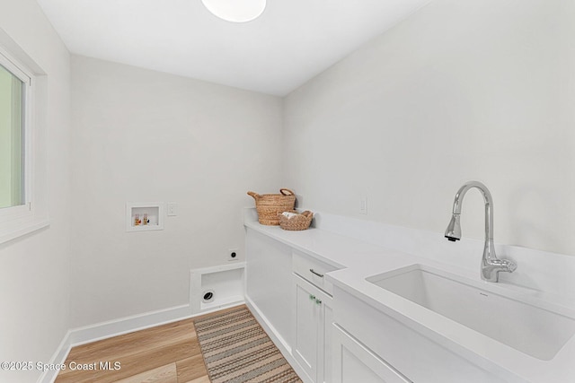 washroom with sink, cabinets, washer hookup, electric dryer hookup, and light wood-type flooring