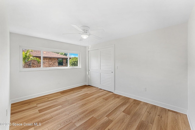 unfurnished bedroom featuring ceiling fan, light wood-type flooring, and a closet