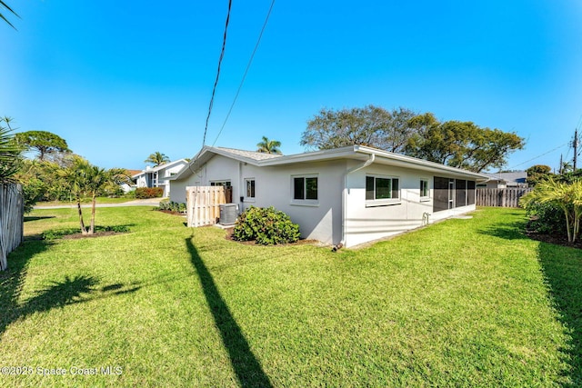 rear view of property with a sunroom and a lawn