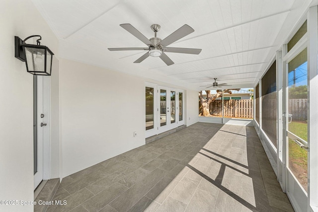 unfurnished sunroom with ceiling fan